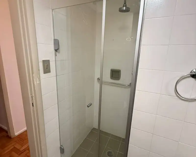 Box de abrir incolor com perfil cromado e azulejo branco, em Indianópolis