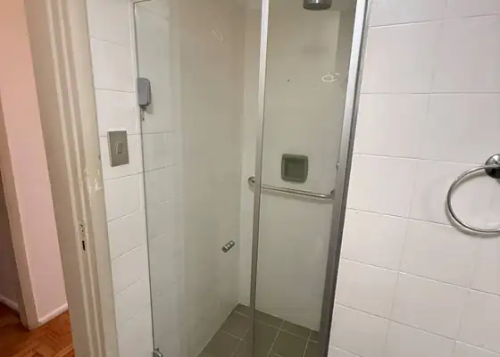 Box de abrir incolor com perfil cromado e azulejo branco, em Indianópolis