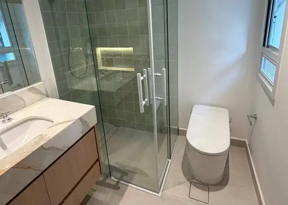 Box de canto com perfil branco, azulejo verde e nicho com LED, nos Jardins