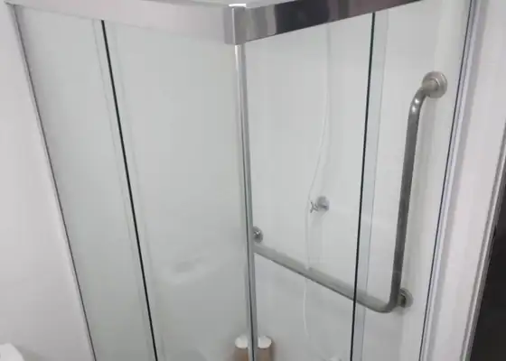 Box de canto incolor com perfil prata e barra de apoio, em Indianópolis
