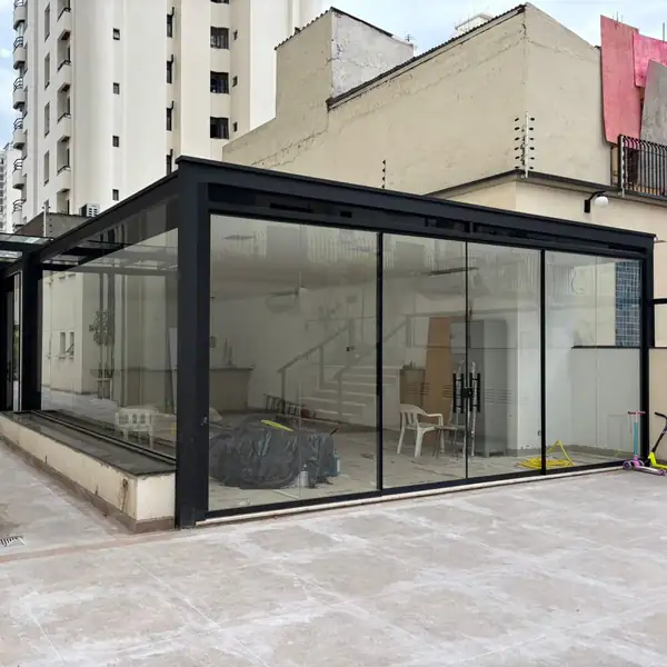 Cobertura e fechamento em vidro laminado com perfil preto em terraço, obra da PS do Vidro