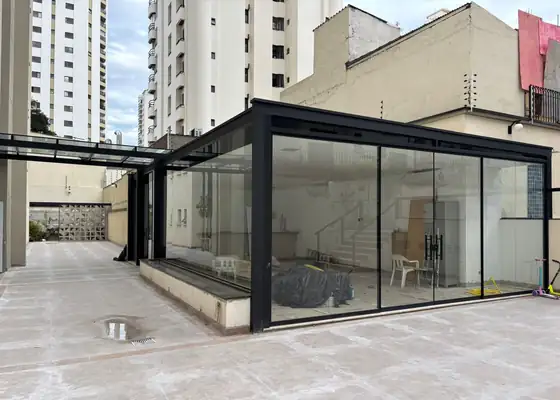 Cobertura e fechamento de vidro com perfil preto em terraço