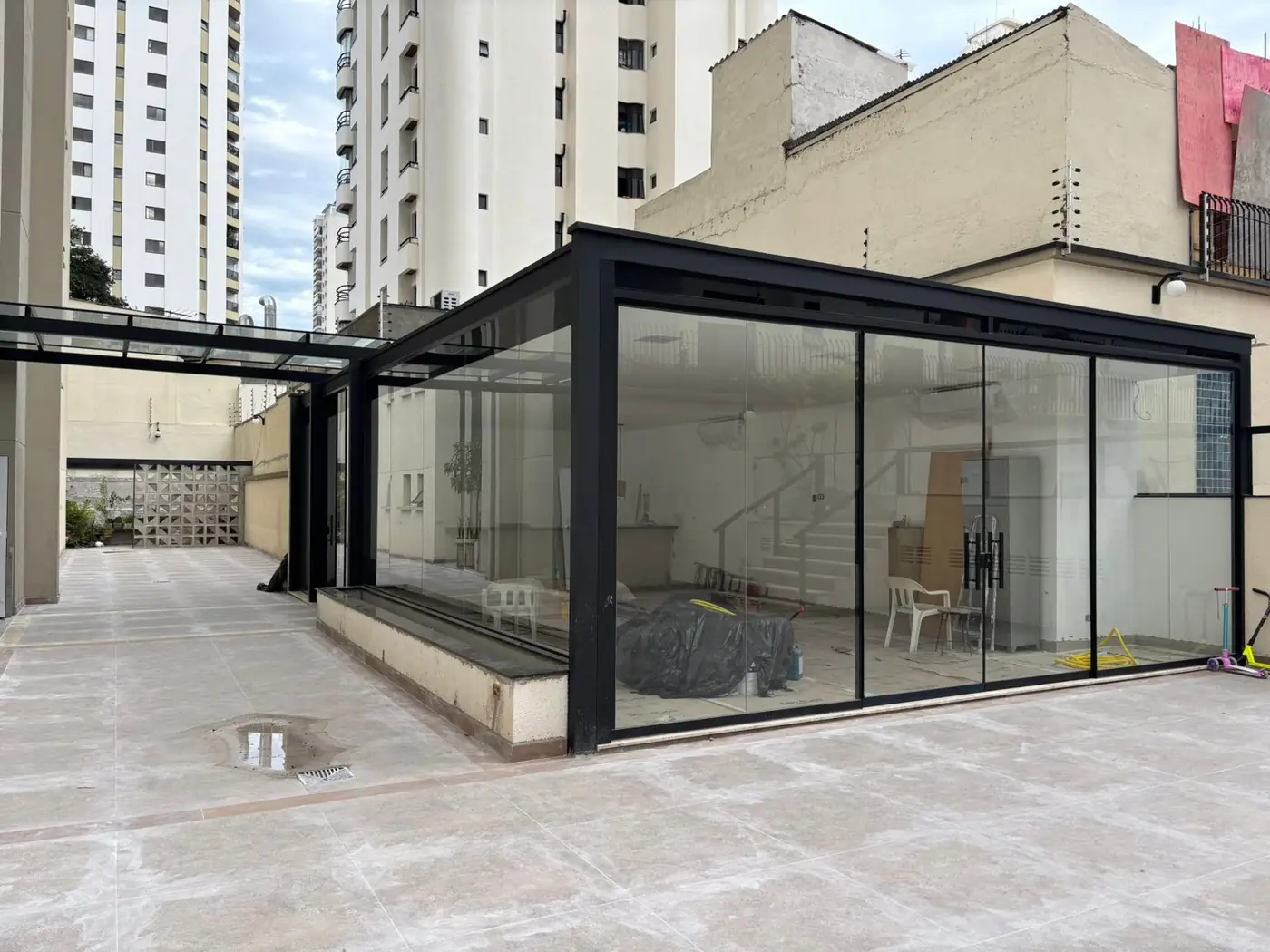 Cobertura e fechamento de vidro com perfil preto em terraço