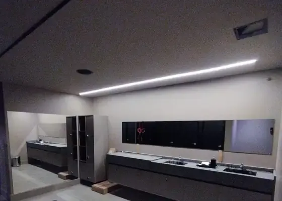 Espelhos sobre as bancadas do vestiário de uma academia na Vila Andrade, obra da PS do Vidro
