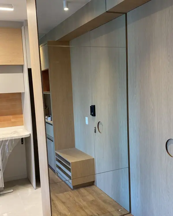 Espelhos em junção do piso ao teto em closet com marcenaria