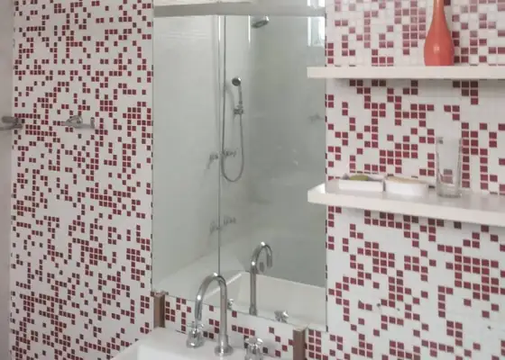 Espelho vertical entre pastilhas vermelhas e brancas em banheiro, em Indianópolis