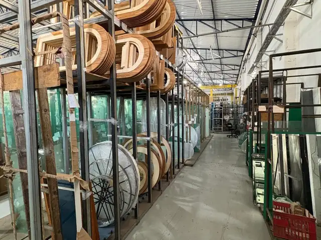 Estoque de espelhos redondos e molduras de madeira na fábrica