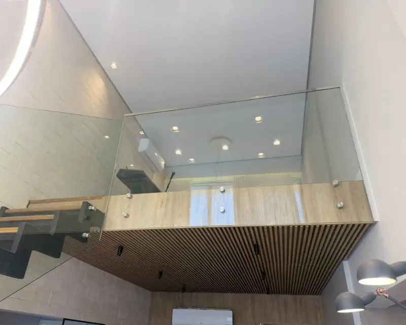 Guarda-corpo de vidro com botões de inox em mezanino e escada, na Vila Olímpia