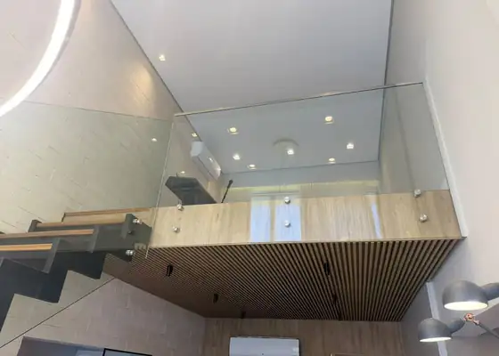 Guarda-corpo de vidro com botões de inox em mezanino e escada, na Vila Olímpia