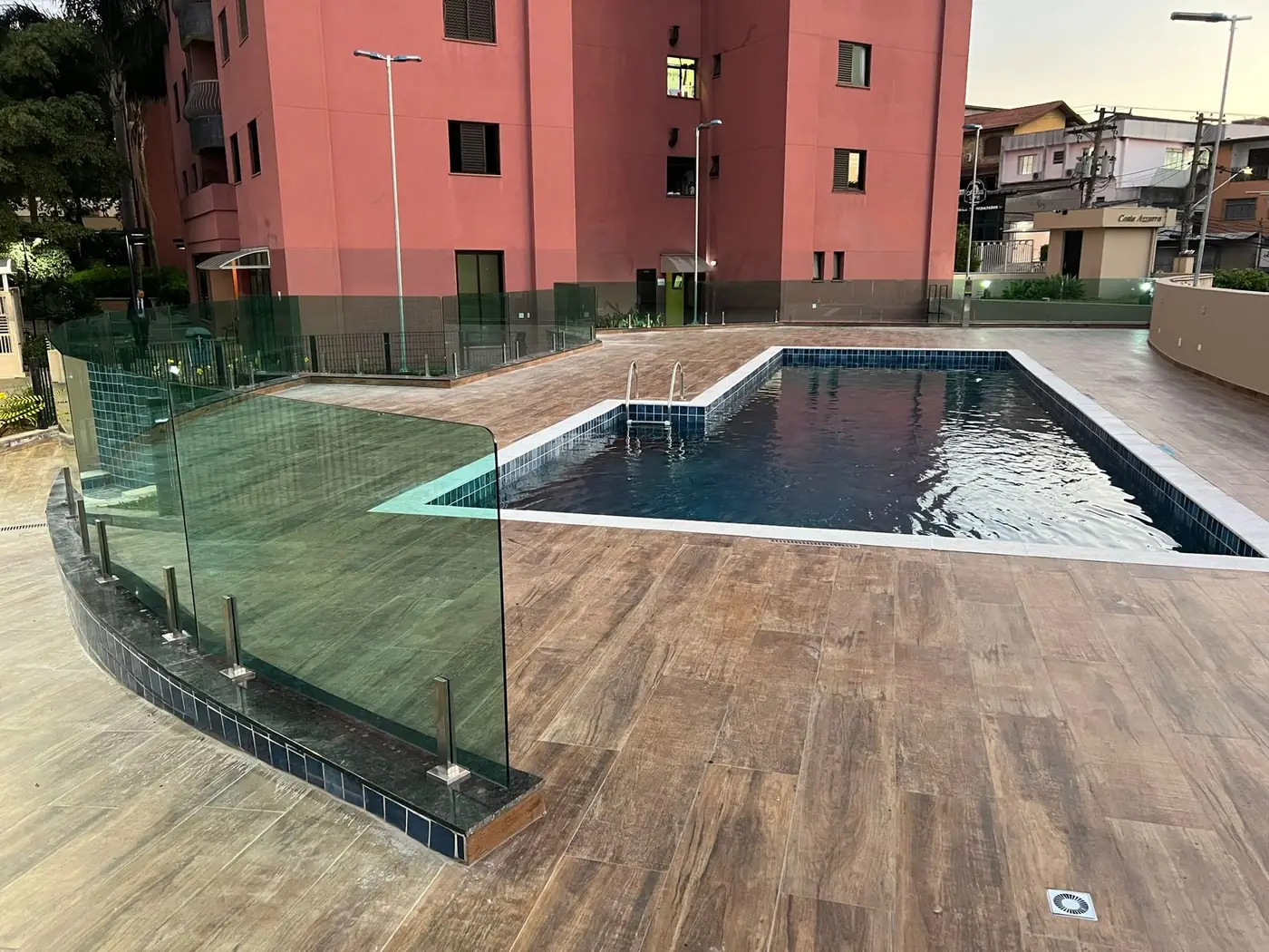 Guarda-corpo de vidro com torres de inox na área da piscina