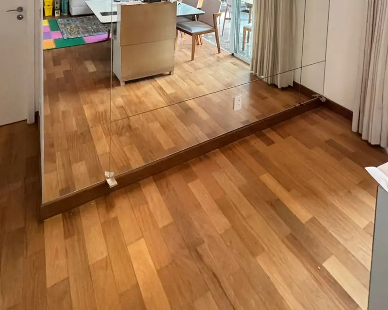 Parede de espelho ampliando a sala, em Moema