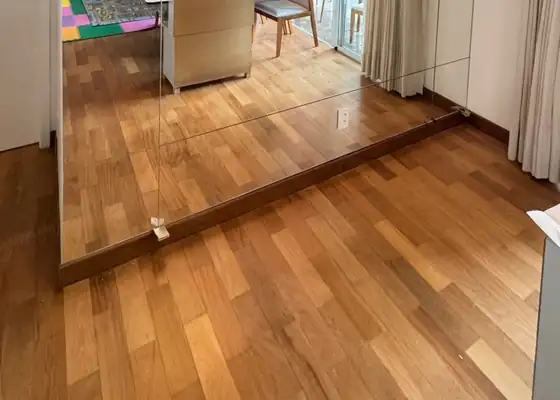 Parede de espelho ampliando a sala, em Moema