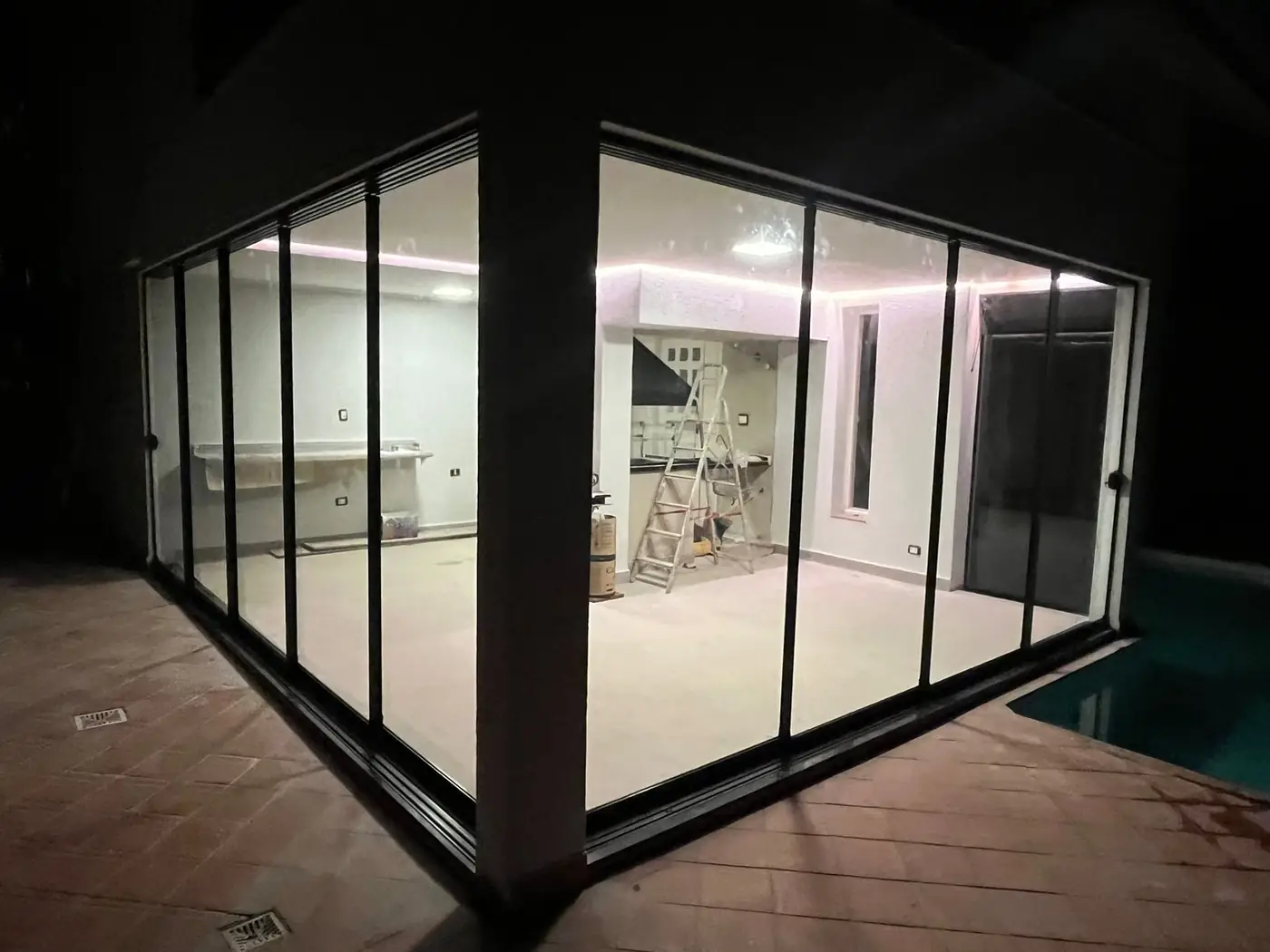 Fechamento com portas de correr de vidro, iluminado à noite