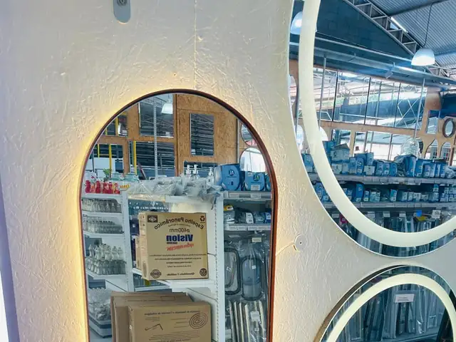 Espelhos oval e redondos com LED na parede do showroom da Vila Olímpia