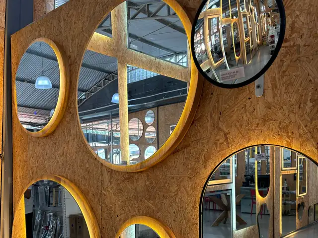 Espelhos redondos com LED em painel de madeira no showroom da Vila Olímpia