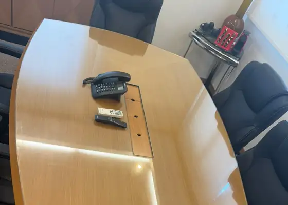 Tampo de vidro sobre mesa de reunião de madeira em escritório, na Vila Olímpia